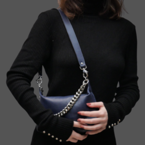 La photo représente une jeune femme portant un petit sac bleu avec une anse chaine